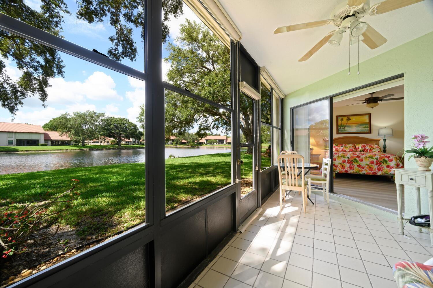 6030 Southeast Martinique Drive, Unit 102 Stuart, FL 34997 - Photo 8 of 31 a view of a porch with furniture and a lake view