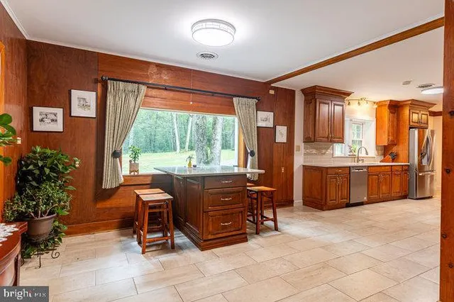 a kitchen with stainless steel appliances granite countertop a refrigerator and a sink
