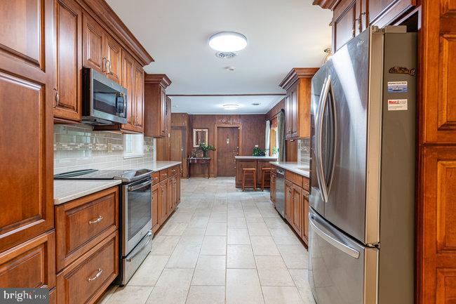 10246 Golf Course Road Fayetteville, PA 17222 - Photo 32 of 62 a large kitchen with stainless steel appliances granite countertop a refrigerator and a stove