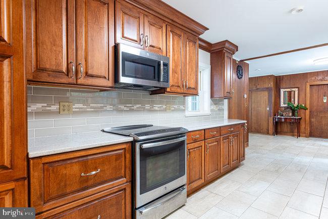 10246 Golf Course Road Fayetteville, PA 17222 - Photo 33 of 62 a kitchen with stainless steel appliances granite countertop a stove a sink and a microwave