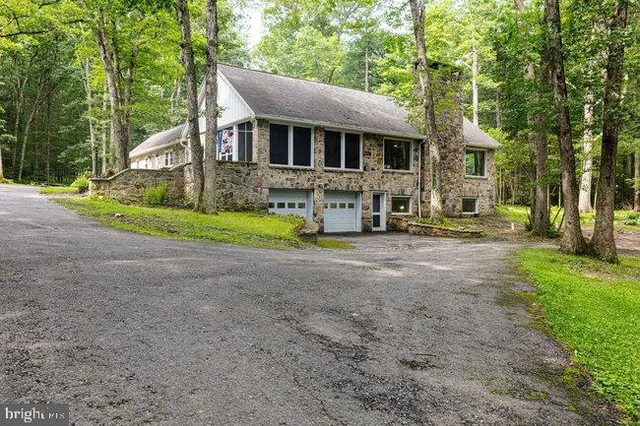 a front view of a house with a yard and trees