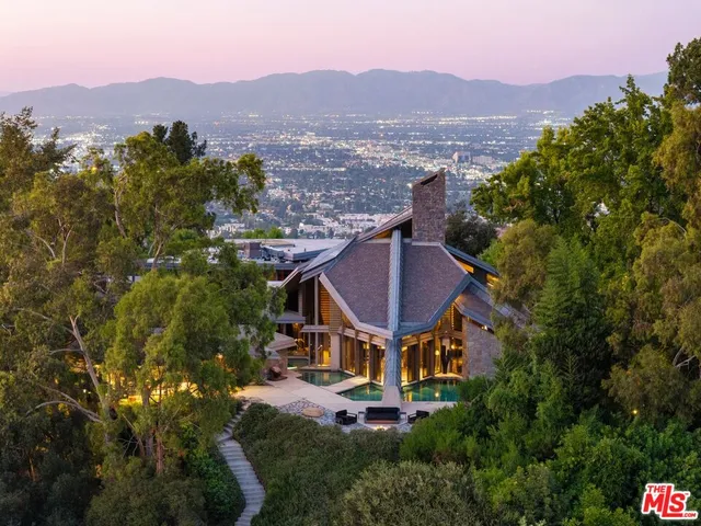 an aerial view of a house with a mountain in the background