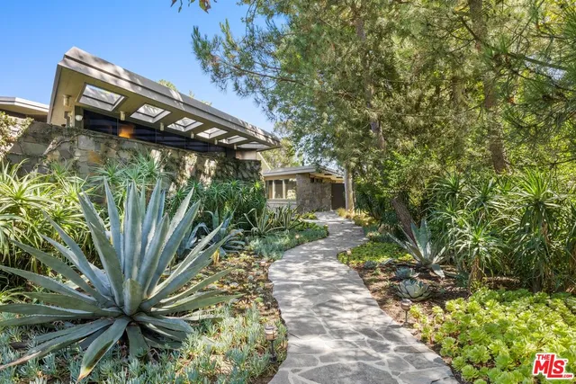 a backyard of a house with lots of green space and fountain