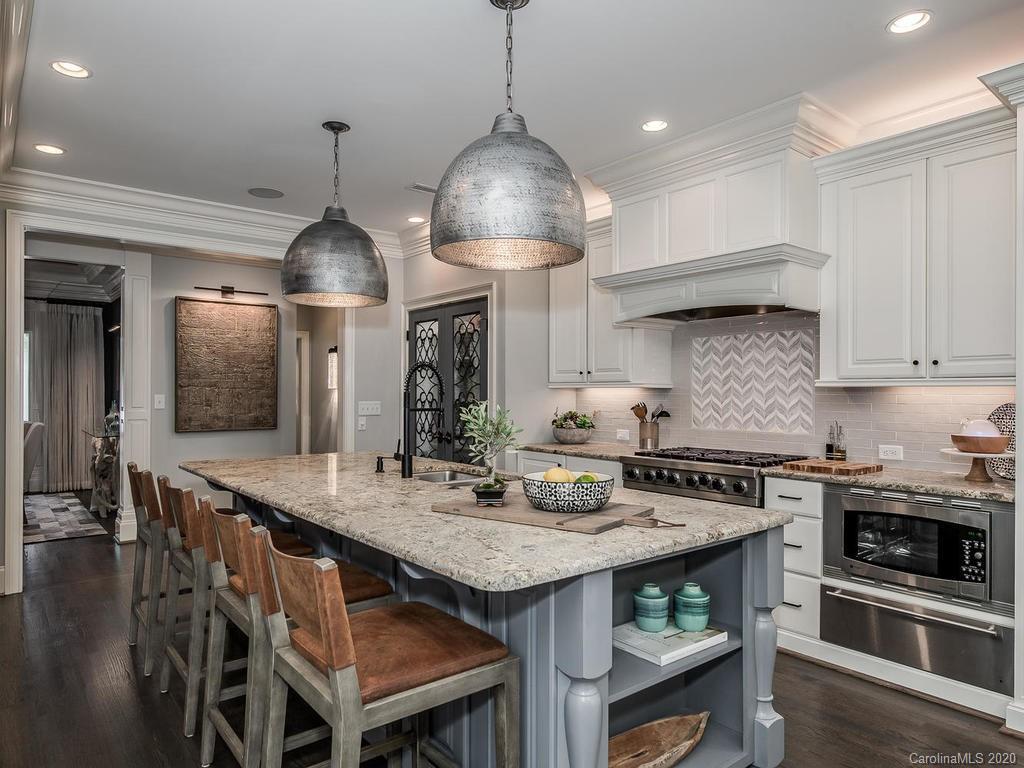 19506 Mary Ardrey Circle Cornelius, NC 28031 - Photo 5 of 36 a kitchen with granite countertop a stove a kitchen island a sink dishwasher and white cabinets with wooden floor