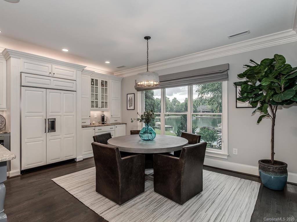 19506 Mary Ardrey Circle Cornelius, NC 28031 - Photo 7 of 36 a dining room with furniture wooden floor a potted plant and a chandelier