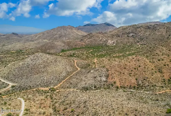 a view of a dry yard with mountains in the background