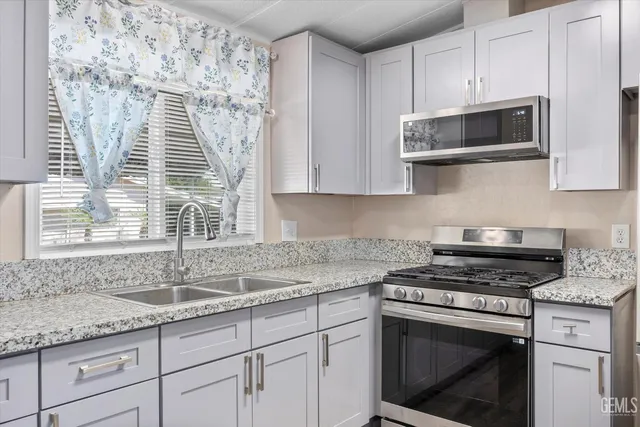 a kitchen with granite countertop a sink cabinets and wooden floor