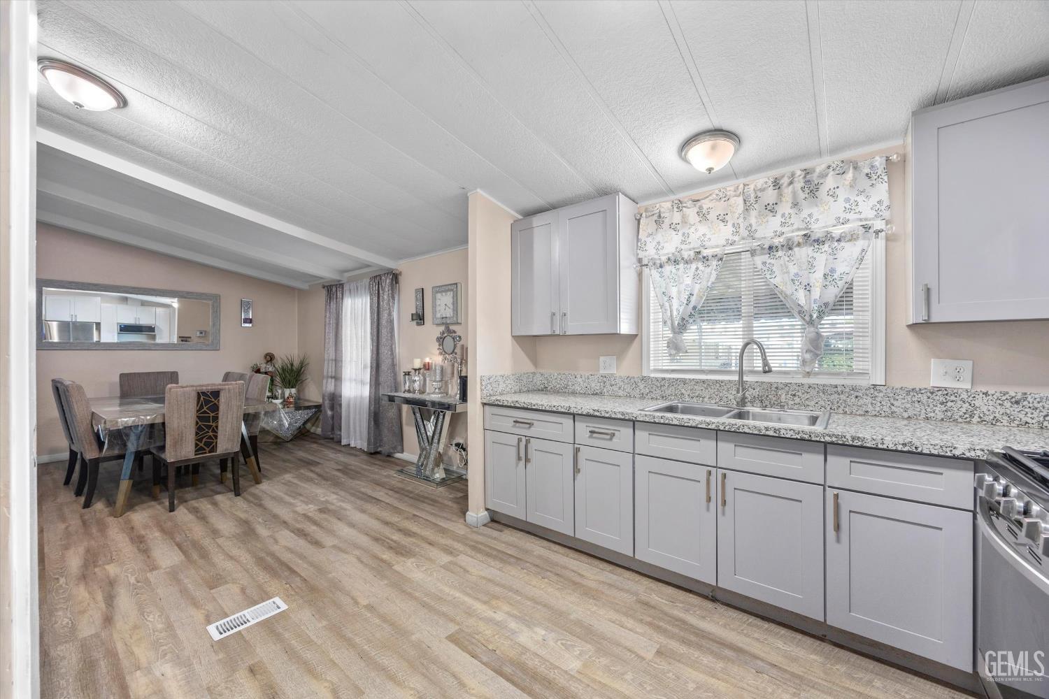 Undisclosed Address Delano, CA 93215 - Photo 19 of 43 a kitchen with granite countertop a sink cabinets and wooden floor