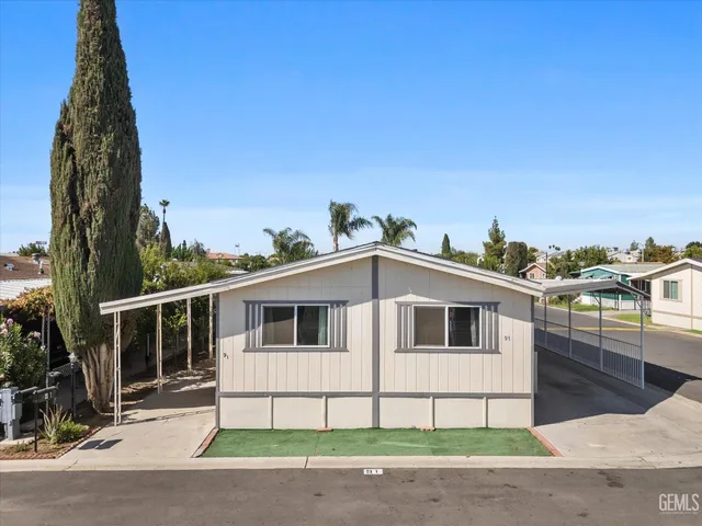 a white house with a large window and yard