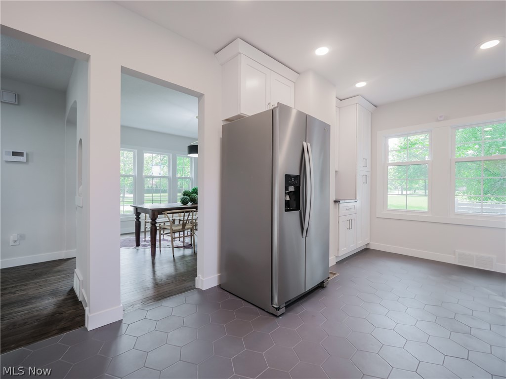 14160 Onaway Road Cleveland, OH 44120 - Photo 12 of 35 Kitchen with dark tile flooring, white cabinetry, and stainless steel refrigerator with ice dispenser