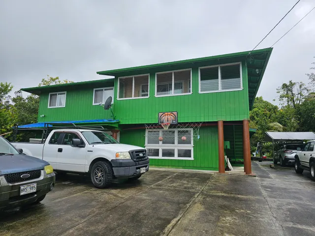 a front view of a house with a garden and parking