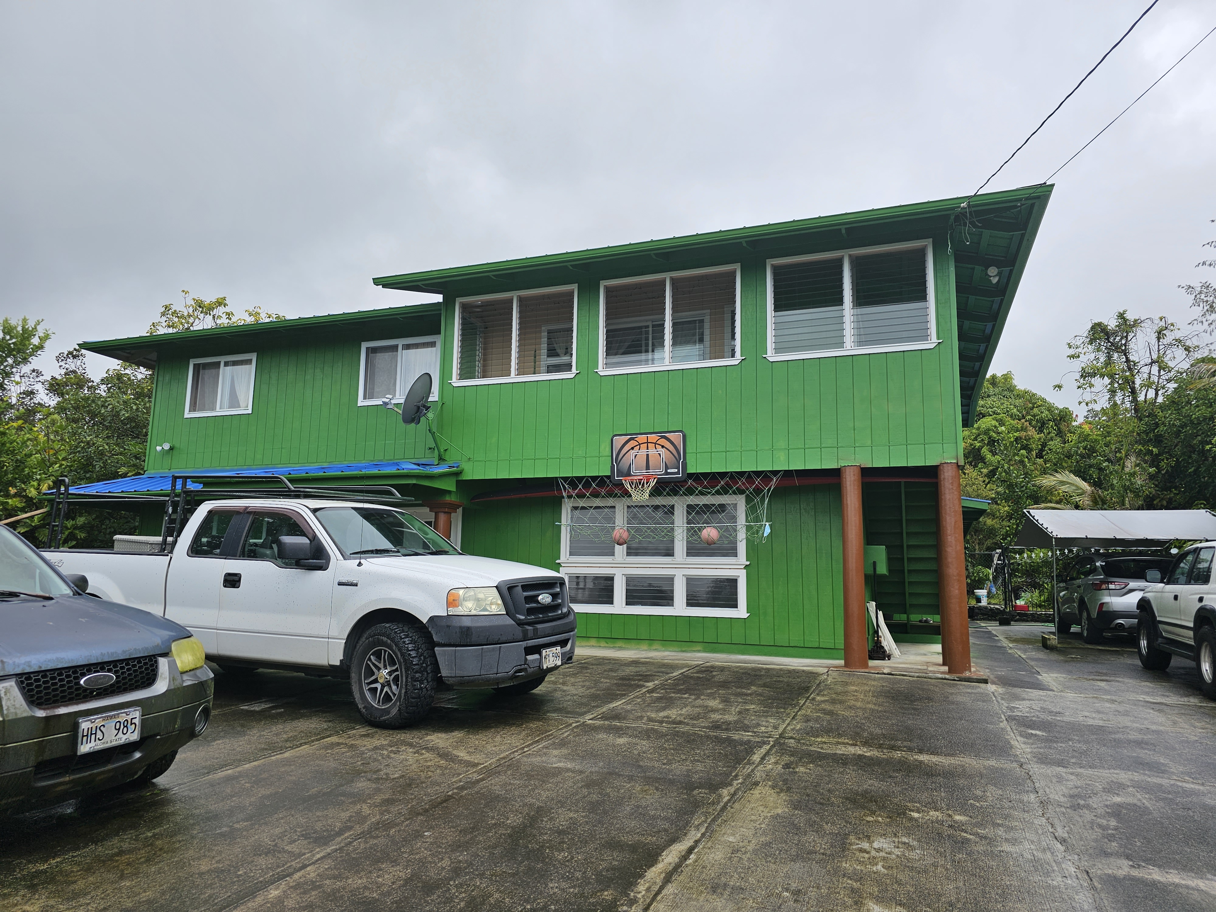 a front view of a house with a garden and parking