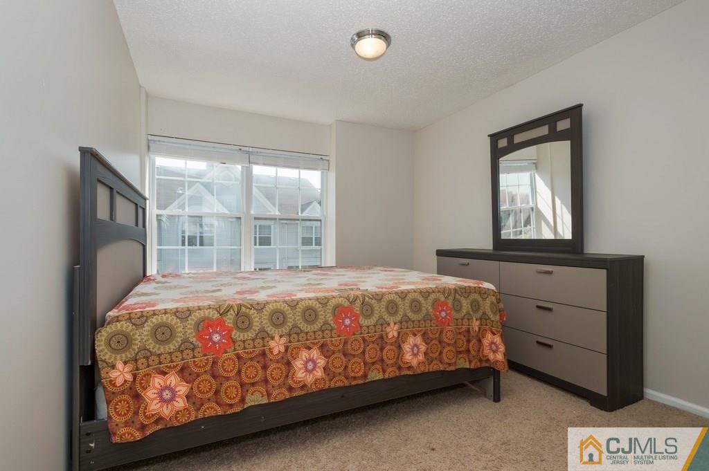 85 Prestwick Way, Unit 85 Edison, NJ 08820 - Photo 11 of 18 a bed sitting in a bedroom next to a window
