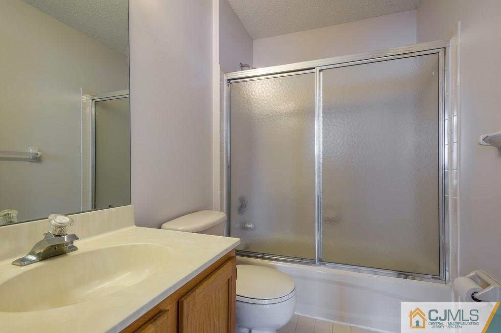 85 Prestwick Way, Unit 85 Edison, NJ 08820 - Photo 13 of 18 a bathroom with a granite countertop sink toilet and shower