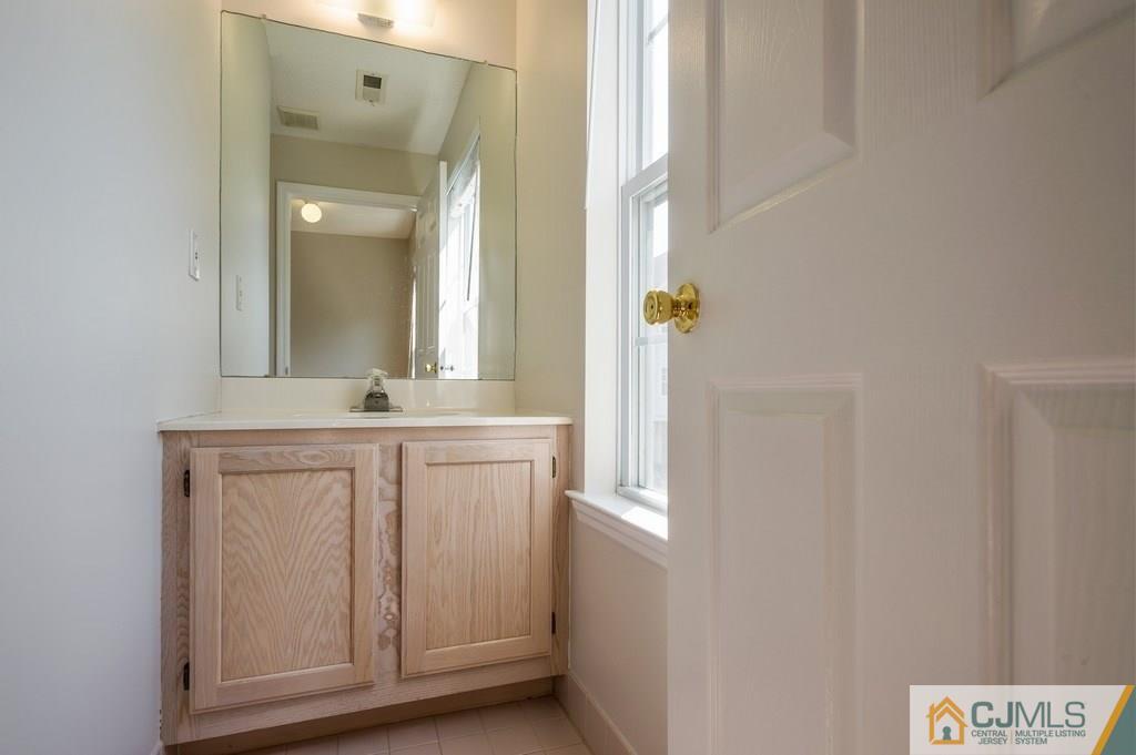 85 Prestwick Way, Unit 85 Edison, NJ 08820 - Photo 14 of 18 a bathroom with a sink a mirror and a window