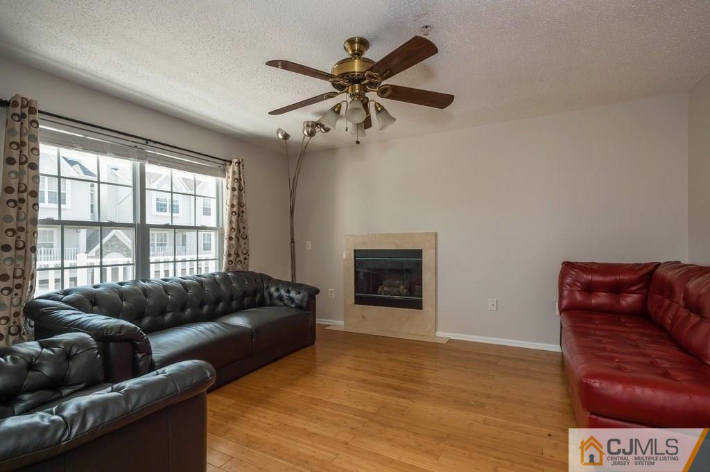 85 Prestwick Way, Unit 85 Edison, NJ 08820 - Photo 4 of 18 a living room with furniture and a fireplace
