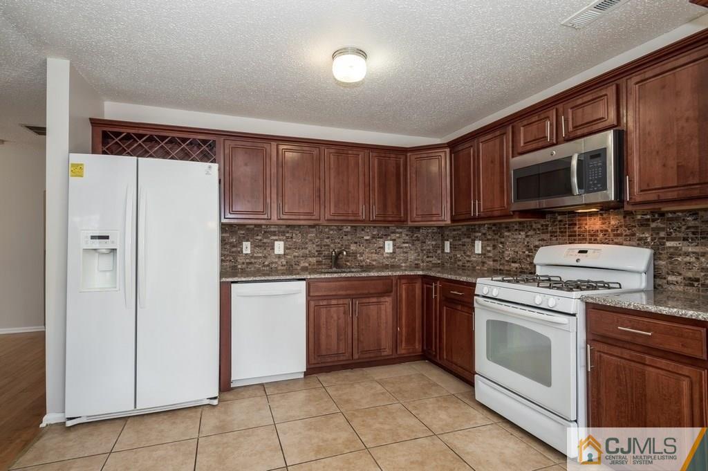 85 Prestwick Way, Unit 85 Edison, NJ 08820 - Photo 5 of 18 a kitchen with cabinets stainless steel appliances and a sink