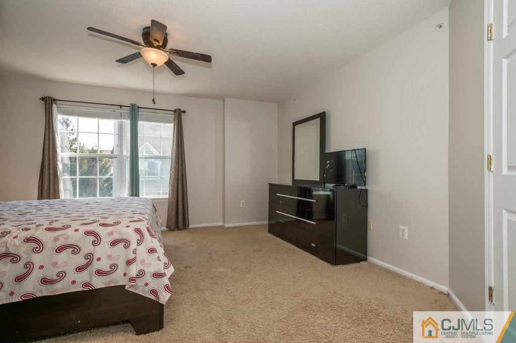 85 Prestwick Way, Unit 85 Edison, NJ 08820 - Photo 9 of 18 a bedroom with a bed and a television