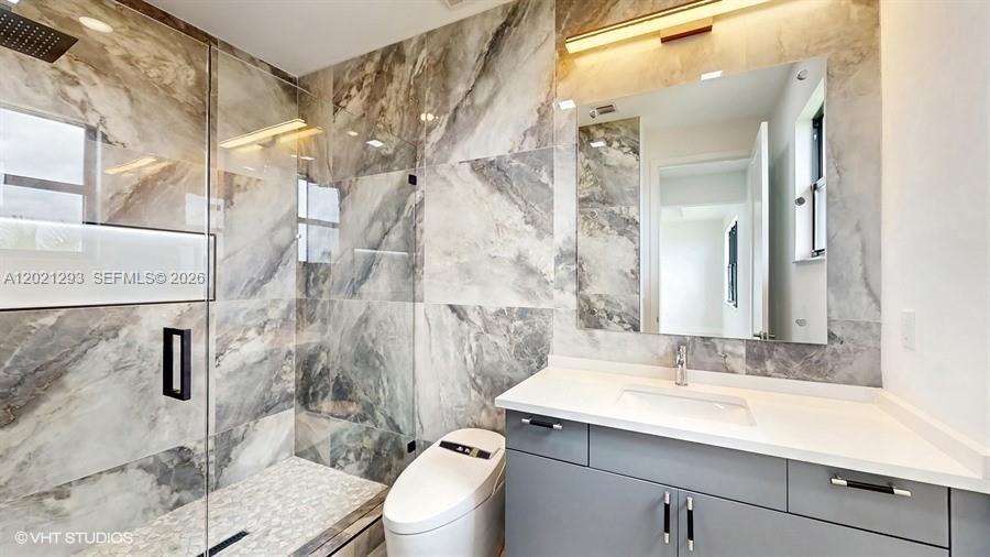 8350 Royal County Down Road Boca Raton, FL 33434 - Photo 23 of 52 a bathroom with a sink and mirror with toilet