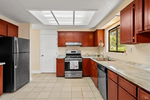 a kitchen with stainless steel appliances granite countertop a refrigerator stove top oven a sink and dishwasher