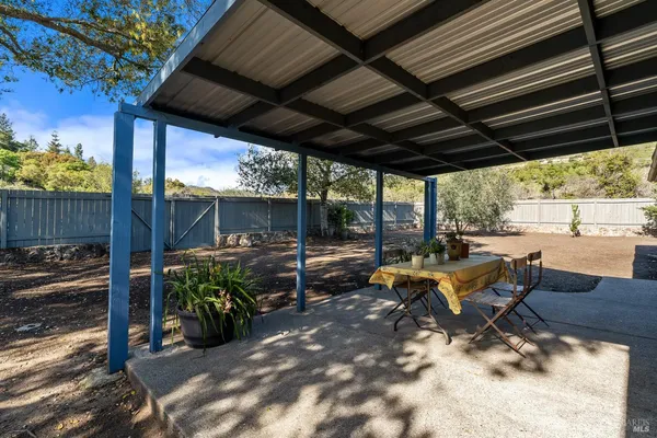 a view of a patio with table and chairs potted plants with wooden floor and fence