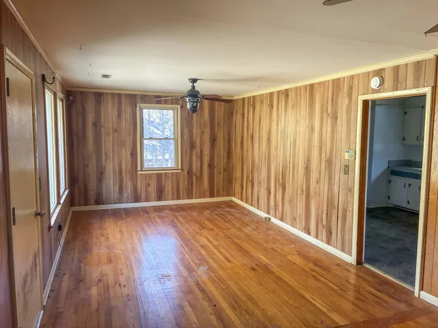 an empty room with wooden floor and a window