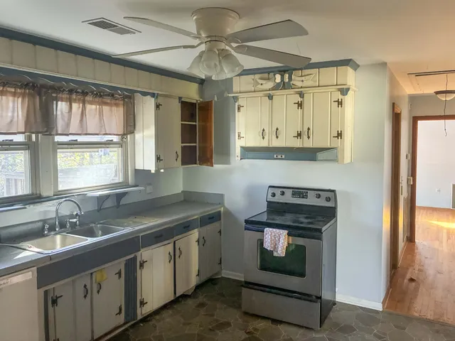 a kitchen with stainless steel appliances granite countertop white cabinets and a granite counter tops