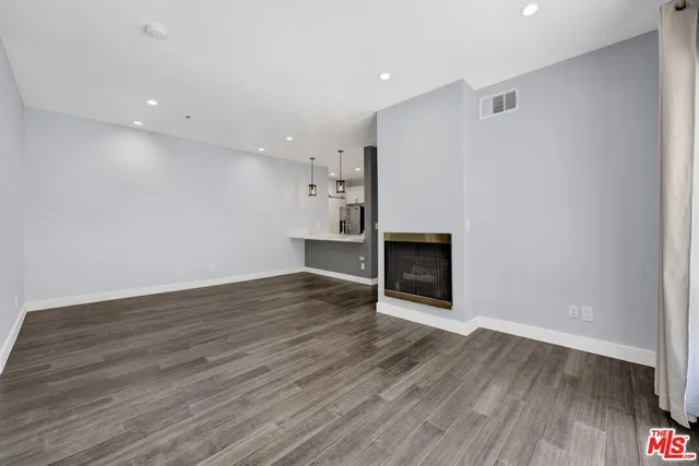 a view of a room with wooden floor and fireplace