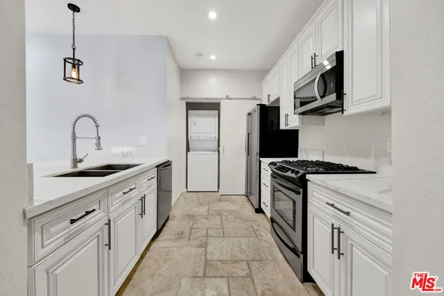 a kitchen with stainless steel appliances granite countertop a stove a sink and a refrigerator