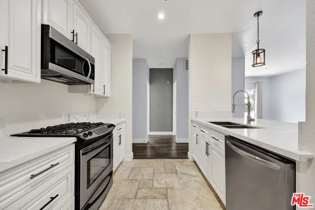 a kitchen with stainless steel appliances a stove a sink and a microwave