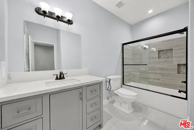 a bathroom with a toilet a sink and glass door