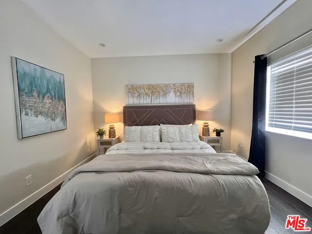 a large bed sitting in a bedroom next to a window