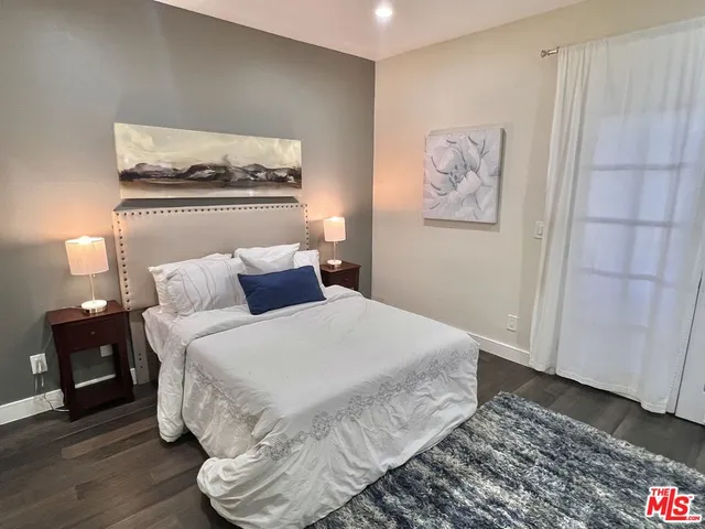 a bedroom with a bed and painting on the wall