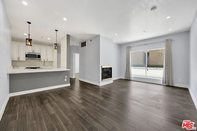 a view of large kitchen with large window and stainless steel appliances