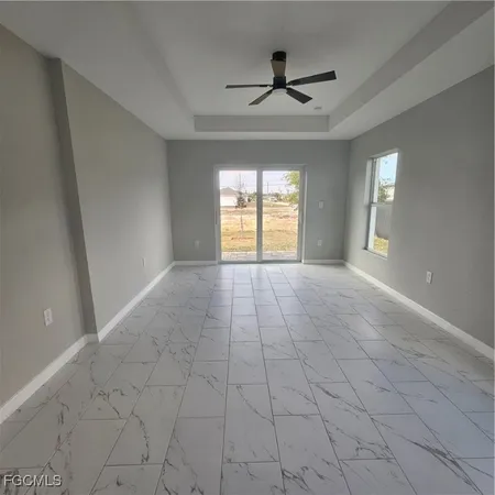 a view of a livingroom with a ceiling fan & windows