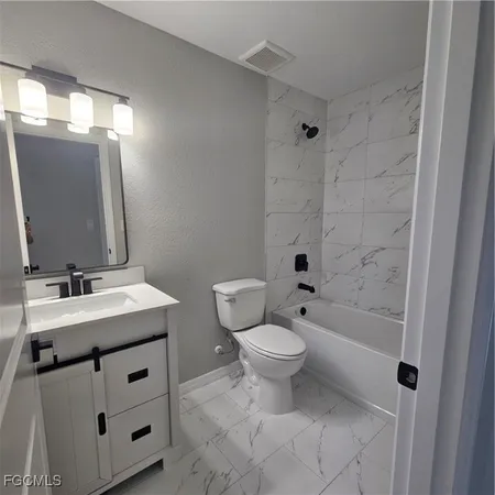 a view of an empty room and window with chandelier fan