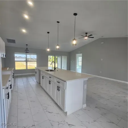 a kitchen with stainless steel appliances granite countertop a sink a stove top oven and a refrigerator