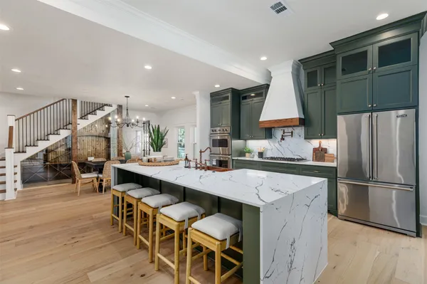 a kitchen with stainless steel appliances a sink a stove a refrigerator and cabinets