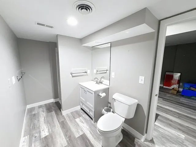 a bathroom with a sink toilet vanity and tub