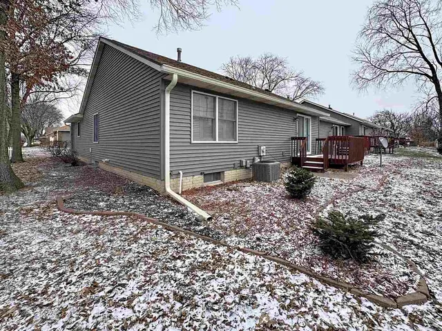 a backyard of a house with wooden fence and large trees