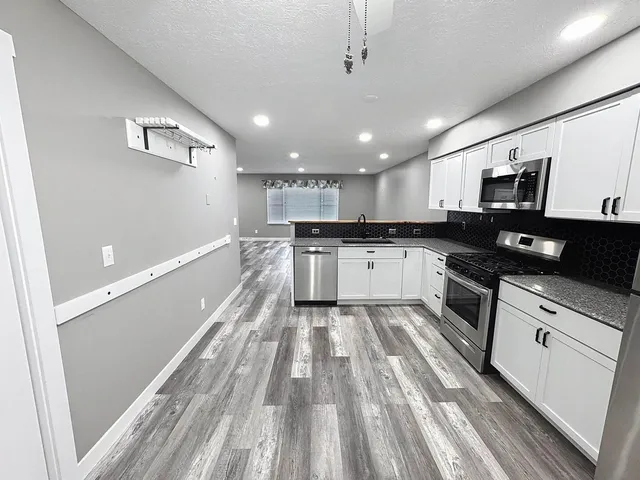 a large kitchen with cabinets a sink and appliances
