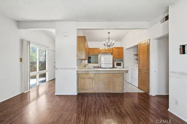 a view of a kitchen with a sink dishwasher a refrigerator and wooden floor