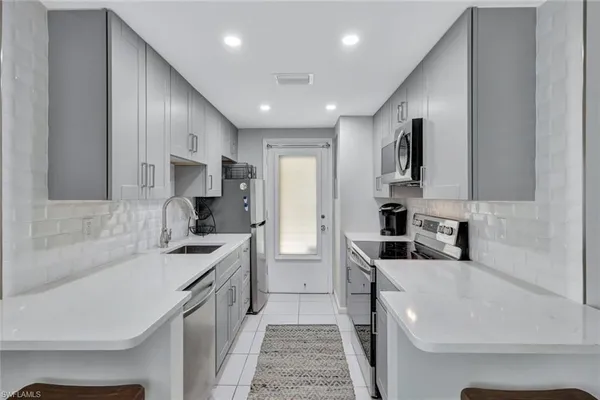 a kitchen with stainless steel appliances a sink stove and refrigerator