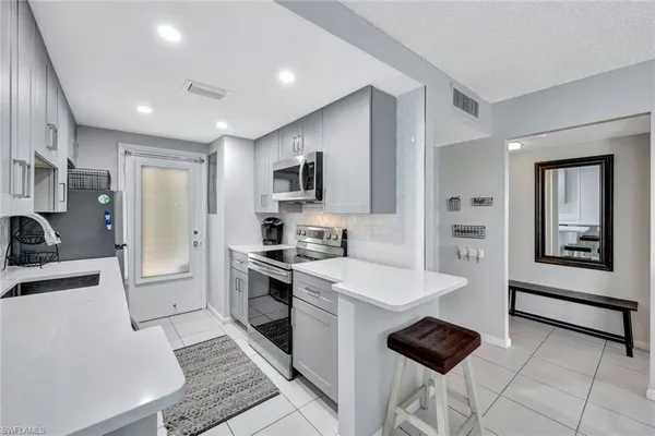 a kitchen with stainless steel appliances a stove a sink a refrigerator and cabinets