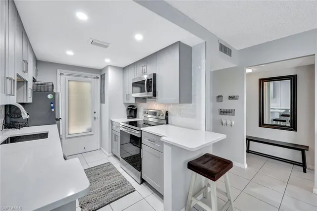 a kitchen with stainless steel appliances a stove a sink a refrigerator and cabinets