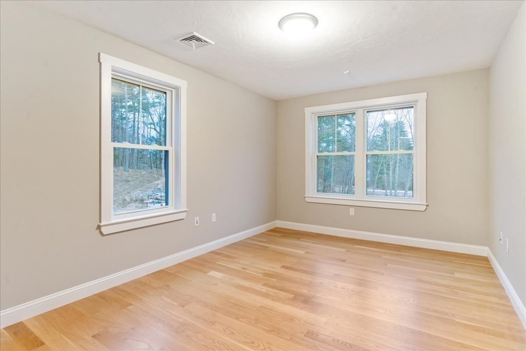 185 Kimball Road Amesbury, MA 01913 - Photo 15 of 24 a view of an empty room with wooden floor and a window