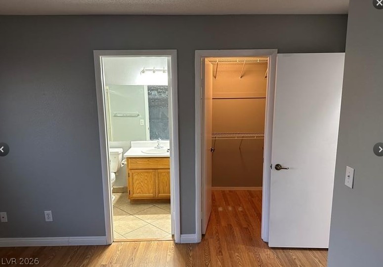 7652 Kalmalii Avenue Las Vegas, NV 89147 - Photo 7 of 9 Conveniently situated, a well-lit bathroom and an organized walk-in closet provide comfort and practicality.