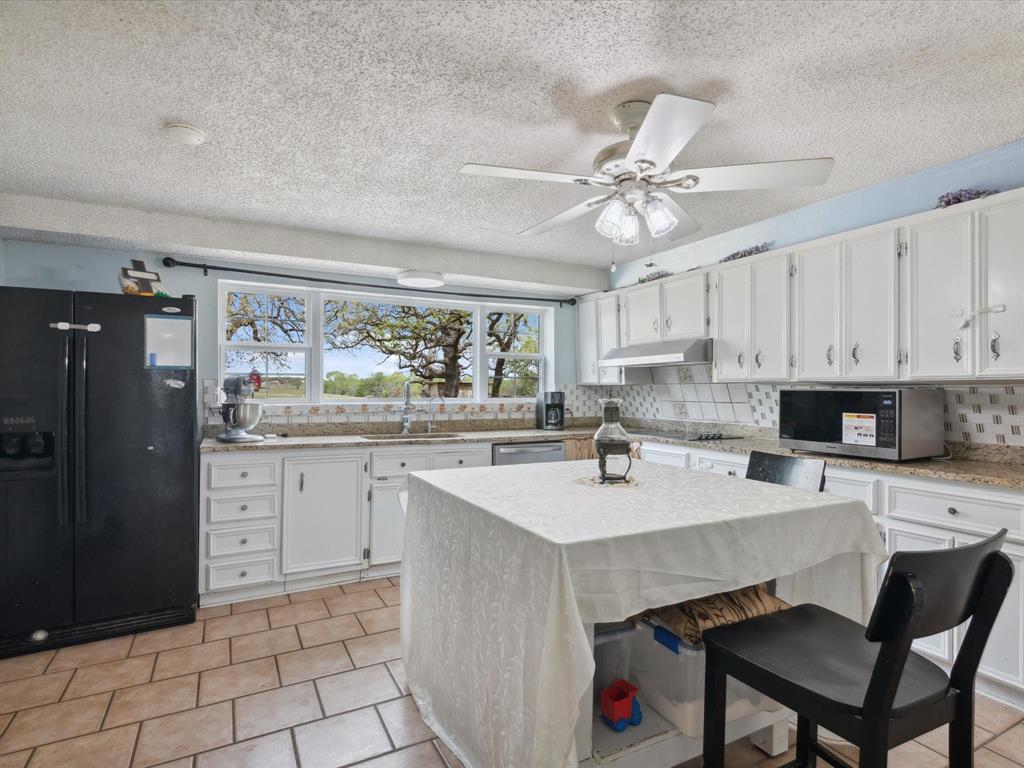265 County Road 4374 Decatur, TX 76234 - Photo 15 of 32 a kitchen with a sink cabinets and wooden floor
