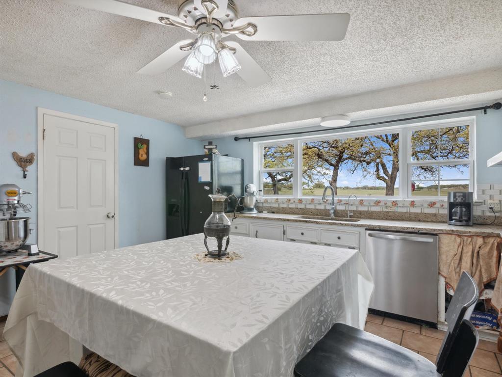 265 County Road 4374 Decatur, TX 76234 - Photo 17 of 32 a kitchen with a table chairs microwave and cabinets