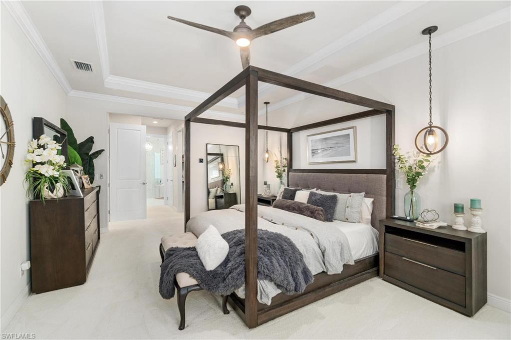 8936 Mustique Lane Naples, FL 34114 - Photo 12 of 29 a bedroom with a large bed and a chandelier